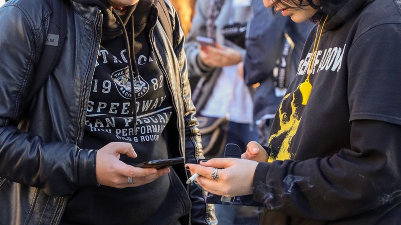 青春短剧《街头少年说》剧照：年轻人在街边看手机